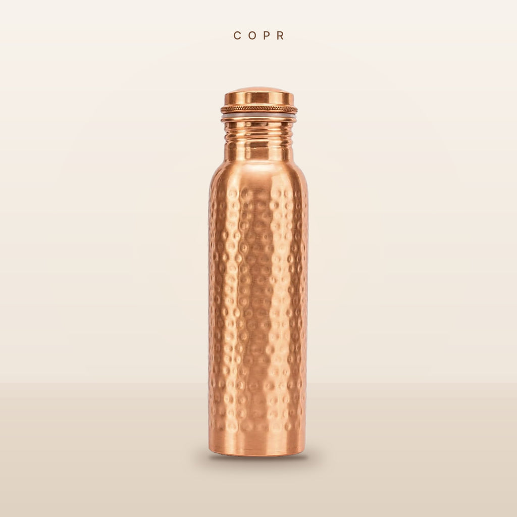 COPR hand-hammered copper water bottle, 34 oz, on a warm cream background