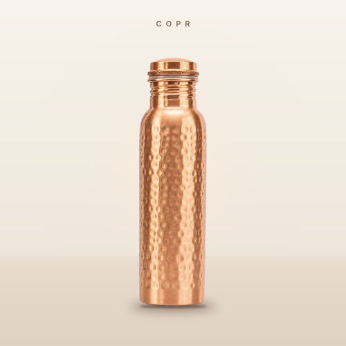 COPR hand-hammered copper water bottle, 34 oz, on a warm cream background